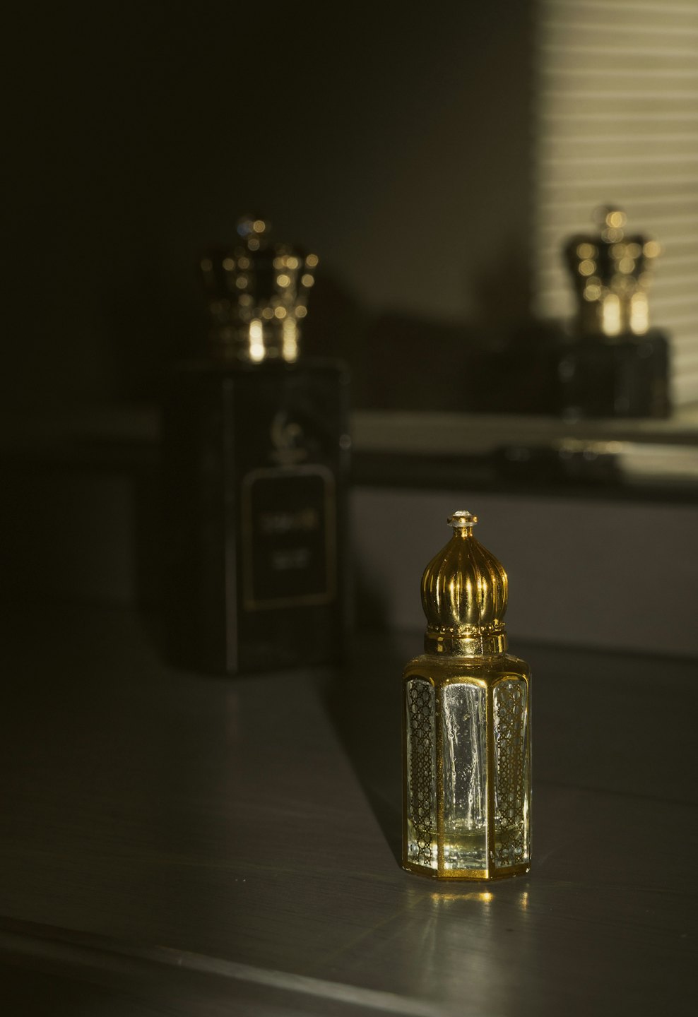 Two elegant perfume bottles sitting on a reflective surface.